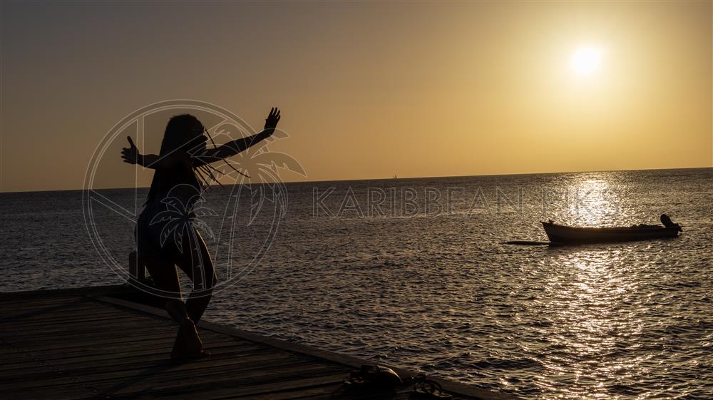 Jeune femme dansant du bèlè au coucher de soleil 